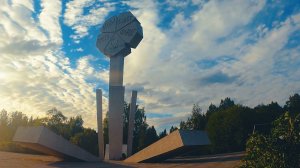 Вечерние облака плывут над монументом «Цветок жизни», посвящённым детям, погибшим во время блокады