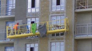 Мокрый фасад: работа со строительной люльки