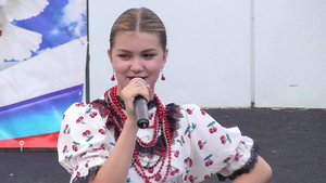 Девушка поёт песню: Топится, топится в огороде баня