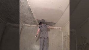 Снятие старой краски и шпаклевки с потолка с помощью скребка в большой комнате