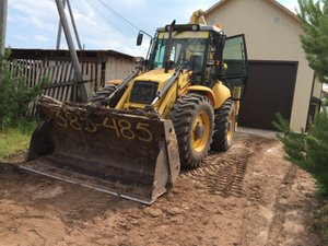 Погрузка самосвала экскаватором- погрузчиком New Holland b 115