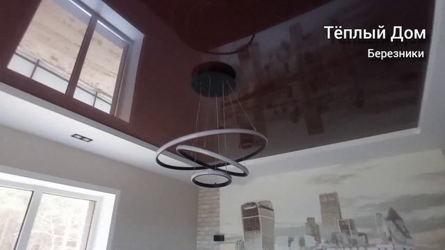 Двухуровневый натяжной потолок с красивой люстрой и светильниками.