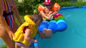 Миша и Даня играют летом в бассейне.Misha and Danya play in the pool in the summer.