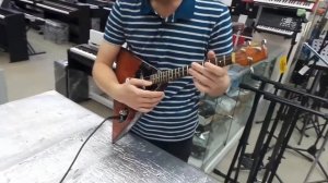 Проверка электробалалайки в музыкальном магазине