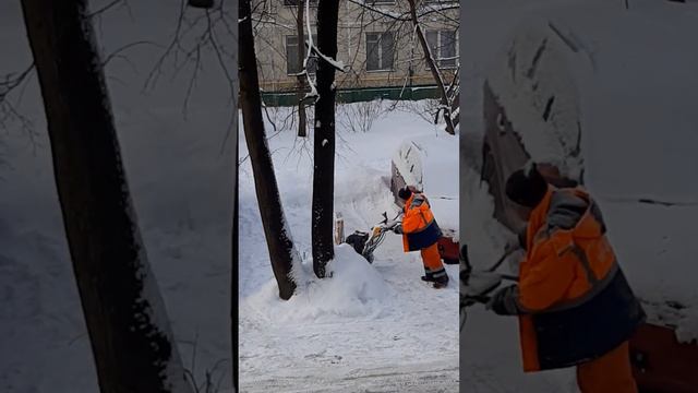 Дворник убирает снег с помощью техники