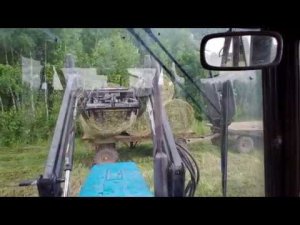 Вывозим рулоны с поля сенаж или сено