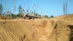 Укладка трубы в траншею. Pipeline laying.