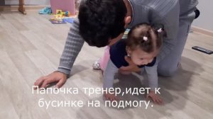 Папа учит дочь ползать.