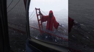 Видео со стоящей у моста смертью в красном плаще.
