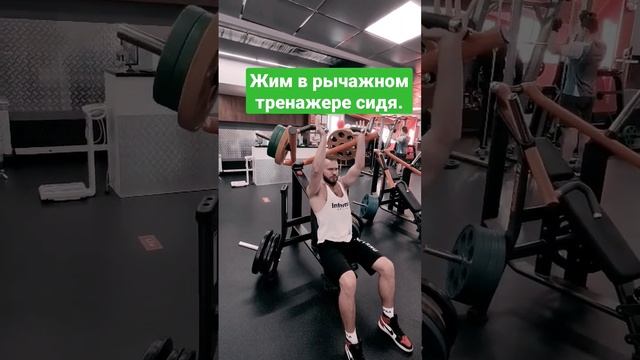 Жим в рычажном тренажере сидя.