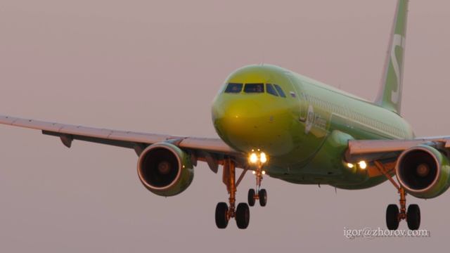 Эйрбас А320 авиакомпании S7 Airlines приземлятся в аэропорту Казани в лучах закатного солнца.