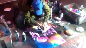 Мужчина рисует картины баллончиком.