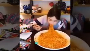 Китайская девушка кушает острую лапшу