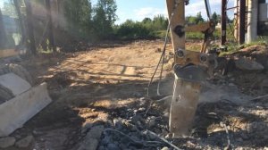 Колесный экскаватор CAT M318D демонтирует железобетонную плиту гидромолотом. Калуга