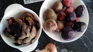 Красный и фиолетовый картофель тушёный с луком на сковороде