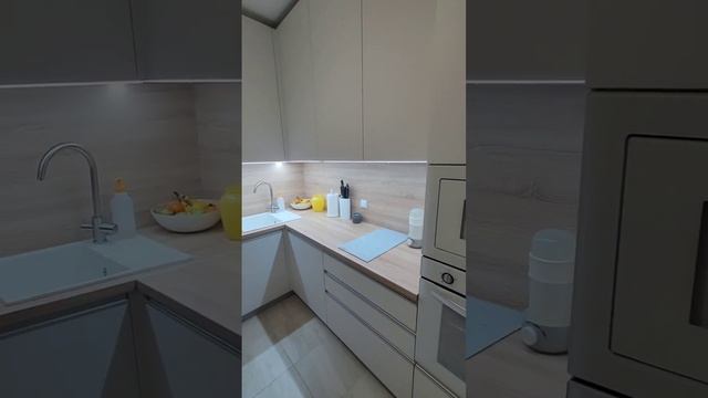 Белая кухня со столешницей и фартуком под светлое дерево, подсветкой рабочей зоны, реечным элементо смотреть онлайн