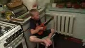 Ребенок играет на гитаре и поет