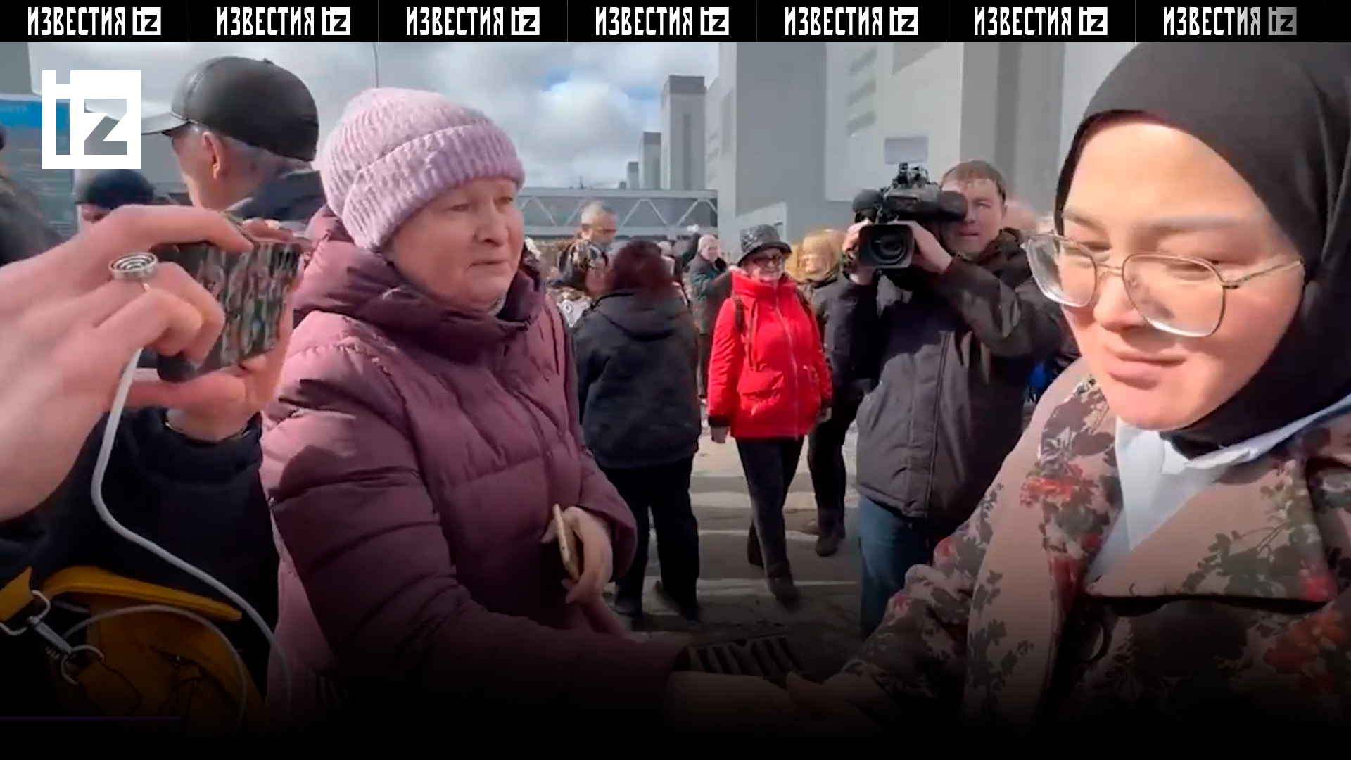 Люди окружили маму подростка, спасшего сотни человек в «Крокусе» / Известия