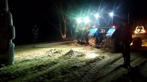 Два трактора вытаскивают груженную фуру из песка