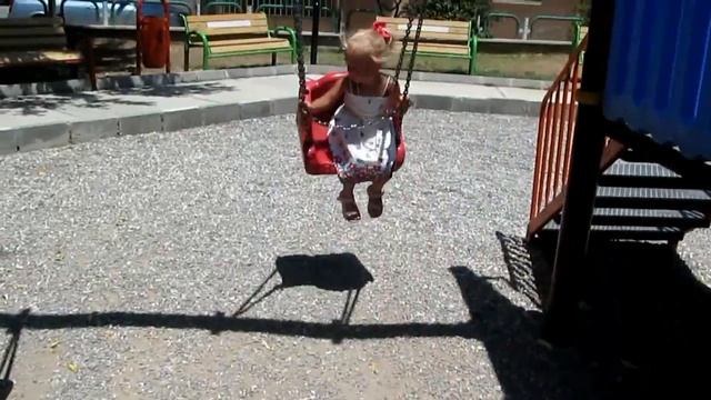 Маленькая девочка качается на качелях Little girl swinging on a swing