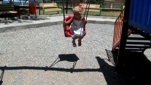 Маленькая девочка качается на качелях Little girl swinging on a swing