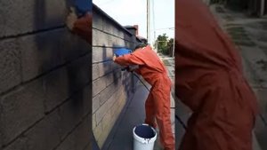 Нанесение каменной краски на забор из блоков