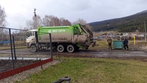 Мусоровоз выгружает мусорный бак