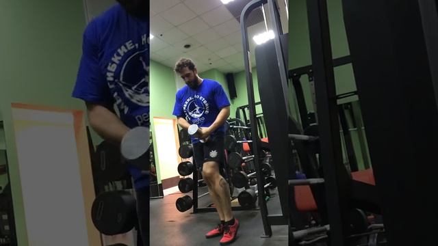 Махи гантелями стоя в наклоне одной рукой