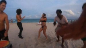 Девушка танцует под барабан на пляже