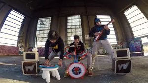 Трио музыкантов из коллектива THE WACKIDS используют детские музыкальные инструменты