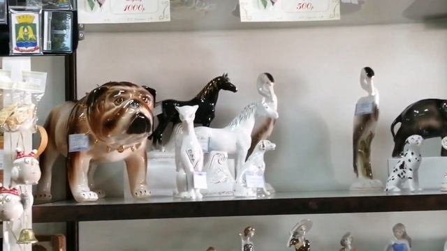 Фарфоровая статуэтка на винтажной полке. Фарфор в магазине 
