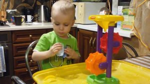 Артем играет с мельницей для песка и воды