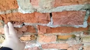 Разрушающийся сырой кирпич под штукатуркой