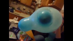 Blonde Girl Blows to Pop a Blue Mouse Ears Balloon