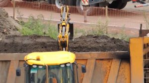 Экскаватор погрузчик Грузит, ровняет и уплотняет землю.