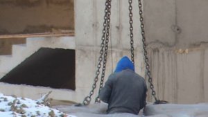 Строительный кран выгружает паллеты из Грузовика с полуприцепом.