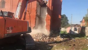 Демонтаж большого кирпичного дома экскаватором, компанией ПЕРВАЯДАЧНАЯ.РФ