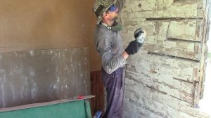 Выпиливание проемов под большие окна в старом деревянном доме в лесном домике на реке - Художник в