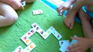 Мальчишки играют в детское домино с фруктами самостоятельно первый раз.