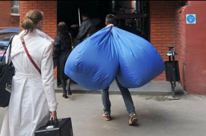 воровство на складе. украл мешок. хищение с предприятия. мужчина с огромными пакетами. грабитель с мешком денег.