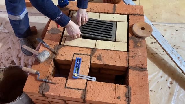 процесс кладки печи мастером с уровнем