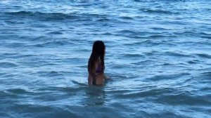Девушка купается в море