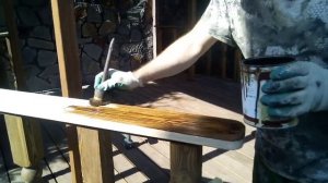 Беседка из лиственницы покрывает  маслом поручни.