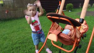 Мария как мама катает пупса на детских качелях /Maria as a mother rolls a baby on a children's swin