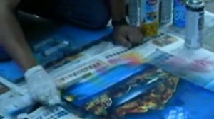 уличный художник рисует картины аэрозольными красками