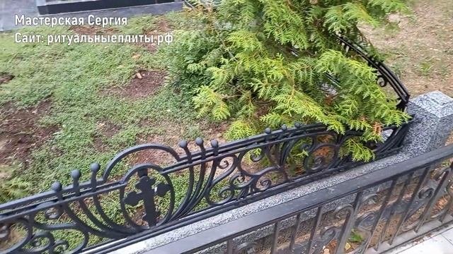 Гранитная ограда с коваными элементами.