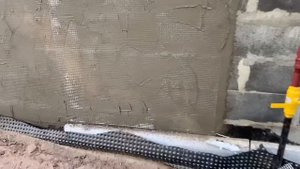 Укрепление цоколя сеткой с использованием штукатурного пистолета.