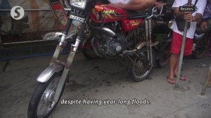 Elevated motorbike taxis help Philippine town navigate persistent floods