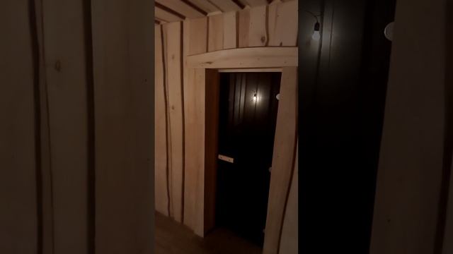 Готовая обналичка и откосы вокруг стеклянной двери необрезной липовой доской в парной