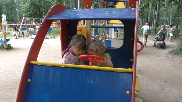 Дети катаются с горки, качаются на качелях на детской площадке в парке. смотреть онлайн